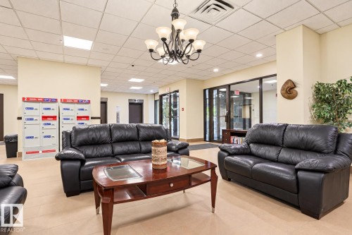 Lounge area featuring a dropped ceiling with recessed lighting, tile flooring, and a chandelier with glass shades - #2005 10149 Saskatchewan Dr Nw, Edmonton, AB 