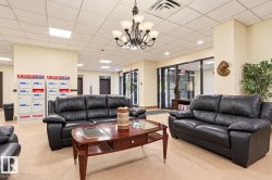 Lounge area featuring a dropped ceiling with recessed lighting, tile flooring, and a chandelier with glass shades - 