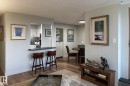 Wood-finish flooring throughout, light-toned wall paint, and a pass-through window with a built-in counter - #2005 10149 Saskatchewan Dr Nw, Edmonton, AB 