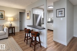 Kitchen passthrough with a breakfast bar and wood-finish flooring - 