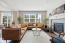 Bright living area featuring a fireplace with a white mantel and tile surround - 3204 Abbott Crescent Sw, Edmonton, AB  - Indoor Photo Showing Living Room With Fireplace 