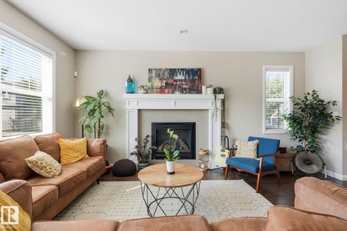 Living area featuring a classic fireplace with a white mantel, hearth, and dark firebox - 3204 Abbott Crescent Sw, Edmonton, AB - Indoor Photo Showing Living Room With Fireplace