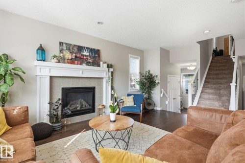 Living area featuring a fireplace with a white mantel and tile surround - 3204 Abbott Crescent Sw, Edmonton, AB - Indoor Photo Showing Living Room With Fireplace