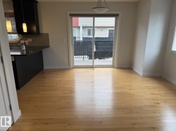 Wood-finish flooring throughout, with a built-in kitchen island featuring a black countertop - 