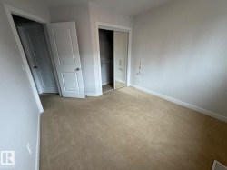 Neutral tone wall paint, carpeted flooring, white trim, solid core doors, mirrored closet doors - 