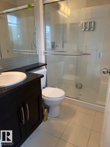 Dark wood-finish vanity with a white vessel sink and dark countertop - #85 9535 217 St Nw, Edmonton, AB 