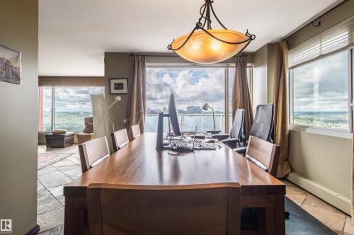 Expansive windows with roller shades, a bronze-finish chandelier, and tile flooring - #1202 10010 119 St Nw, Edmonton, AB 