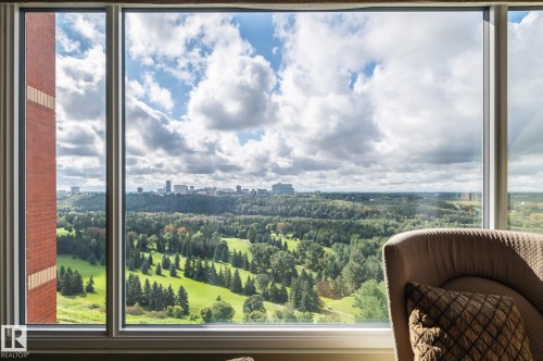 Expansive window offering a sweeping panorama of a distant cityscape and verdant landscape - #1202 10010 119 St Nw, Edmonton, AB 