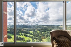Expansive window offering a sweeping panorama of a distant cityscape and verdant landscape - 
