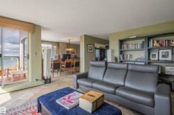 Sliding glass doors leading to a balcony, tile flooring, built-in shelving, and a recessed dining area with a chandelier - 