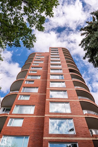 Red brick exterior with multiple stories, curved balconies, and numerous windows - #1202 10010 119 St Nw, Edmonton, AB 