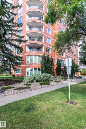 Brick exterior with multiple curved balconies featuring glass railings - #1202 10010 119 St Nw, Edmonton, AB 