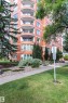 Brick exterior with multiple curved balconies featuring glass railings - #1202 10010 119 St Nw, Edmonton, AB 