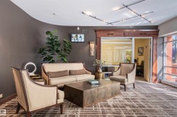 Textured wall covering with a curved accent, glass-paneled entry, full-height windows, and recessed ceiling lighting - 