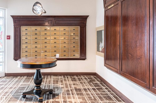 Built-in mailboxes with brass fronts, dark wood trim, and a patterned carpet floor - #1202 10010 119 St Nw, Edmonton, AB 