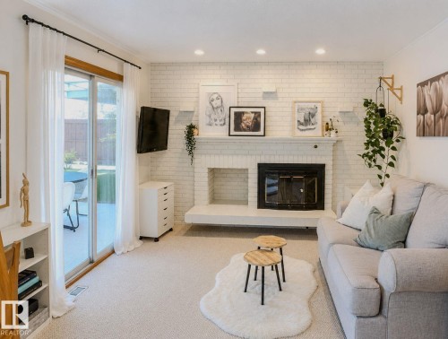 White brick fireplace with an integrated hearth, recessed ceiling lighting, and light-colored carpeting - 3911 117 Street Nw, Edmonton, AB 