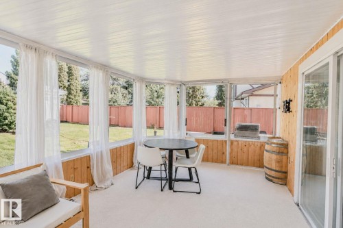 Enclosed patio with wood-paneled walls, white paneled ceiling, and glass sliding doors - 3911 117 Street Nw, Edmonton, AB 