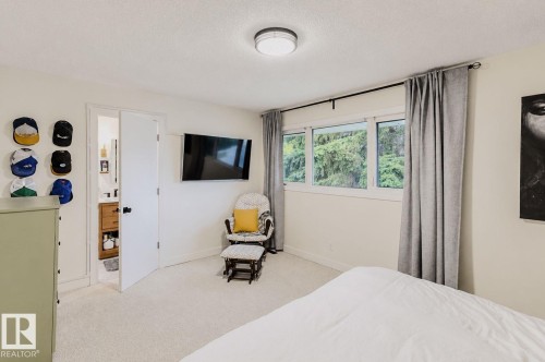 Recessed ceiling light fixture, wall-mounted television, and a multi-pane window with drapery - 3911 117 Street Nw, Edmonton, AB 