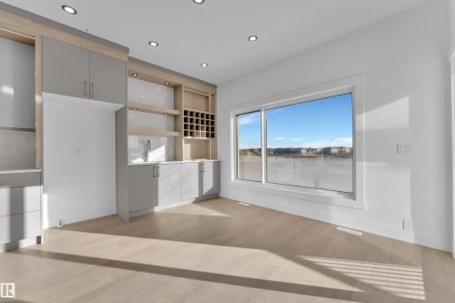 Built-in cabinetry with light wood-finish accents, integrated shelving, and a beverage cooler - 226 Linden Loop, Leduc, AB 