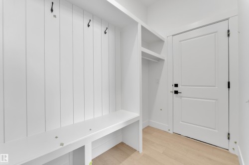 Built-in bench with storage, vertically paneled wall, integrated shelving, and light wood-finish flooring - 226 Linden Loop, Leduc, AB 
