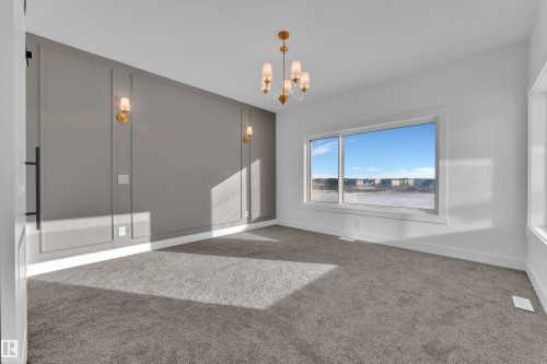 Accent wall with decorative molding and sconce lighting - 226 Linden Loop, Leduc, AB 