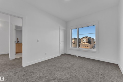 Neutral carpeting in a bright room with a large window - 226 Linden Loop, Leduc, AB 