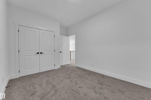 Carpeted flooring, white walls, double-door closet with dark hardware, recessed lighting, and white trim - 226 Linden Loop, Leduc, AB 
