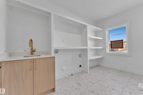 Light wood-finish cabinetry with gold-tone hardware, white countertop, and gold-tone faucet - 226 Linden Loop, Leduc, AB 