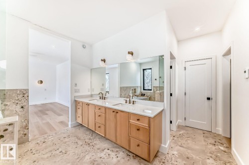 Dual sink vanity with light wood cabinetry, white countertops, and integrated mirrors - 10514 134 Street Nw, Edmonton, AB 