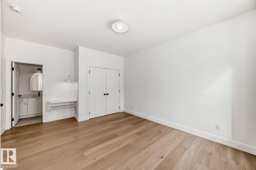 Wood-finish flooring, white walls, and a flush mount ceiling fixture - 10514 134 Street Nw, Edmonton, AB 