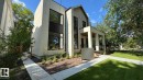 Modern architectural design featuring varied exterior materials, large black-framed windows, a covered entrance, a concrete pathway, and a manicured lawn - 10514 134 Street Nw, Edmonton, AB 