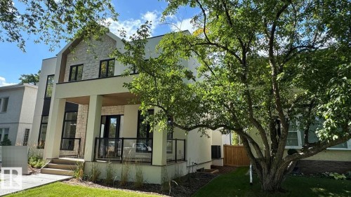 Modern exterior architecture with stone and stucco finishes, covered front entrance, and black-framed windows - 10514 134 Street Nw, Edmonton, AB 