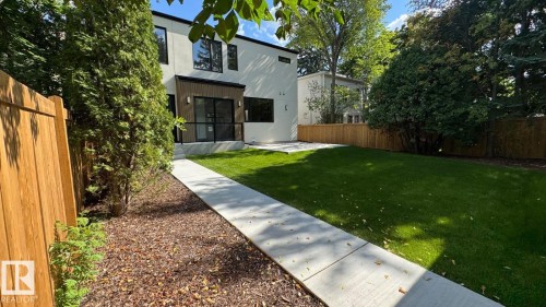 Expansive grassy lawn with a concrete pathway and wood fencing - 10514 134 Street Nw, Edmonton, AB 