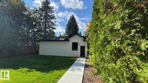 Contemporary exterior with a black trim roofline, white siding, and a dark entry door - 10514 134 Street Nw, Edmonton, AB 