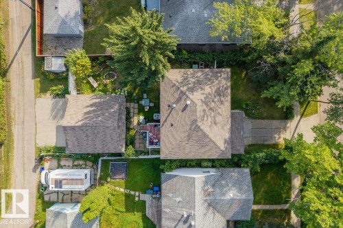 Asphalt shingle roofing, paved driveway, mature trees, and a concrete patio - 14608 93 Avenue Nw, Edmonton, AB 
