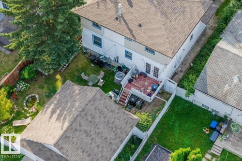 Rear exterior featuring a multi-level wood deck, white vinyl fencing, and a shingle roof - 14608 93 Avenue Nw, Edmonton, AB 