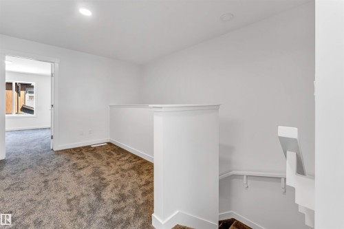 Carpeted landing featuring white painted walls and recessed lighting - #48 710 Mattson Dr Sw Sw, Edmonton, AB 
