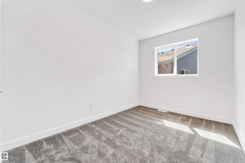 White walls with a single window, gray patterned carpeting, and white trim - #48 710 Mattson Dr Sw Sw, Edmonton, AB 