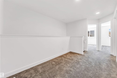 Loft area featuring neutral carpeting, white walls, recessed lighting, and white trim - #48 710 Mattson Dr Sw Sw, Edmonton, AB 