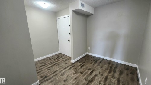 Wood-finish flooring, light neutral-toned walls, and a contemporary flush-mount ceiling light - #101 11803 22 Av Sw, Edmonton, AB 