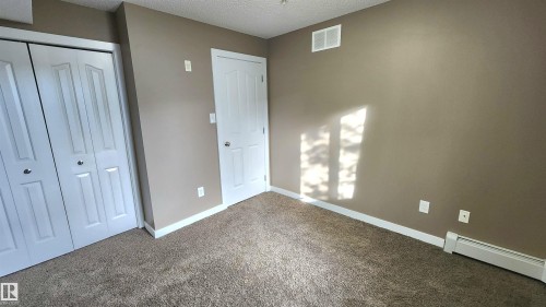Neutral-toned carpeting paired with light brown walls - #101 11803 22 Av Sw, Edmonton, AB 
