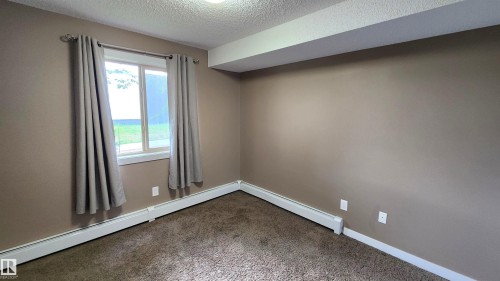 Neutral-toned wall finish, wall-to-wall carpeting, and white trim - #101 11803 22 Av Sw, Edmonton, AB 