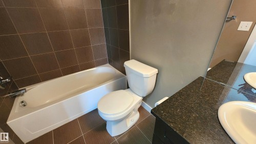 Brown tiled flooring with complementary wall tiling - #101 11803 22 Av Sw, Edmonton, AB 