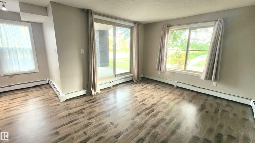 Wood-finish flooring throughout, complemented by light-toned wall paint - #101 11803 22 Av Sw, Edmonton, AB 