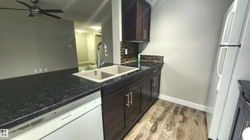 Dark wood-finish cabinetry with silver-tone hardware - #101 11803 22 Av Sw, Edmonton, AB 