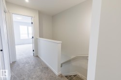 Upper landing featuring light gray carpet flooring and white painted walls - 
