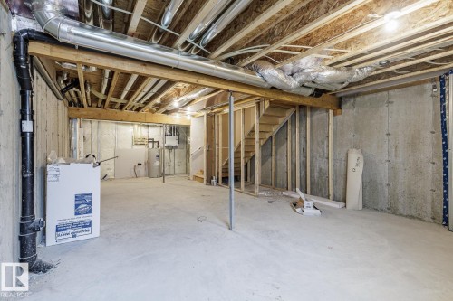 Unfinished basement featuring exposed joists, concrete foundation walls, and a concrete floor - 70 Dansereau Way, Beaumont, AB - Indoor Photo Showing Basement
