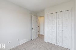 Room featuring light gray carpeting, neutral wall paint, and a white paneled door with black hardware - 