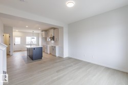 Open-concept living area with light wood-finish flooring - 
