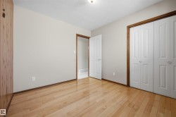 Hardwood flooring, painted walls, bi-fold closet doors, wood-paneled wall, and contrasting wood trim - 